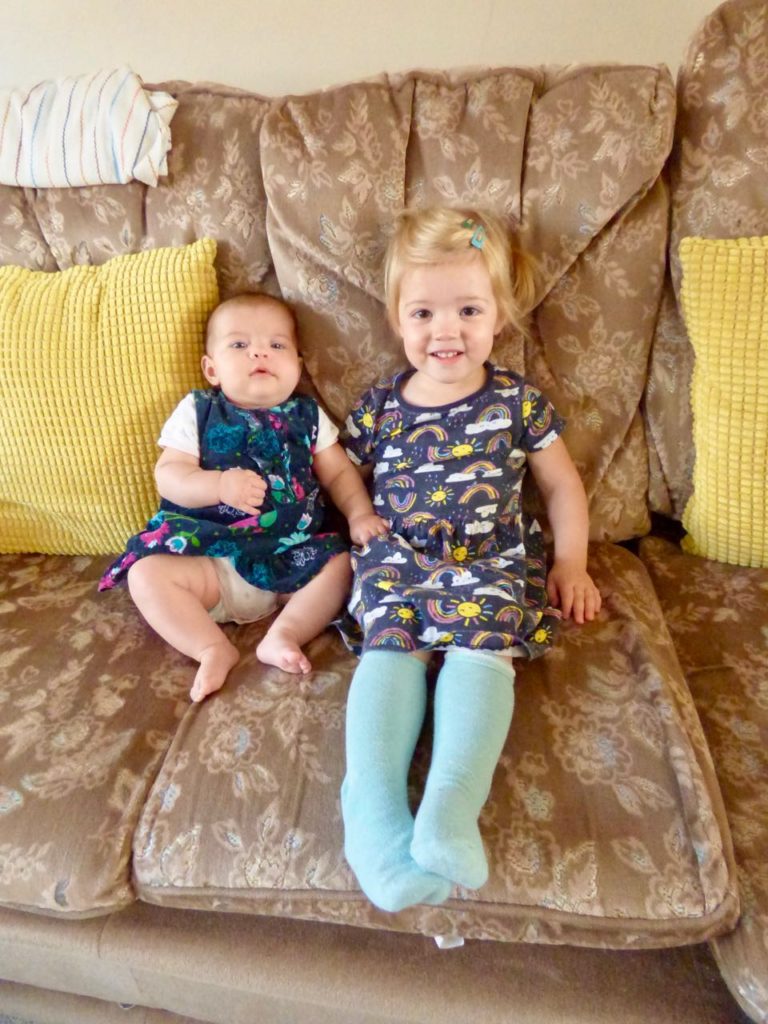 Our three-month old and two-year old sitting sweetly together on the sofa.